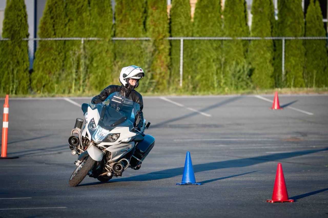 Evan riding a motorcycle through a cone practice course in Vancouver