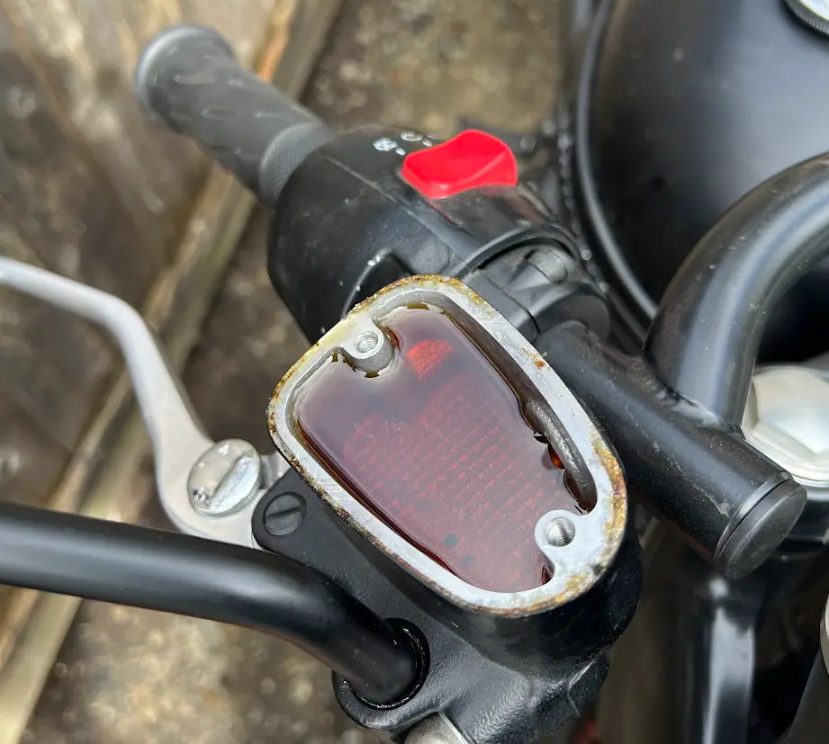 Motorcycle front fork and brake area inspected during brake-fluid service