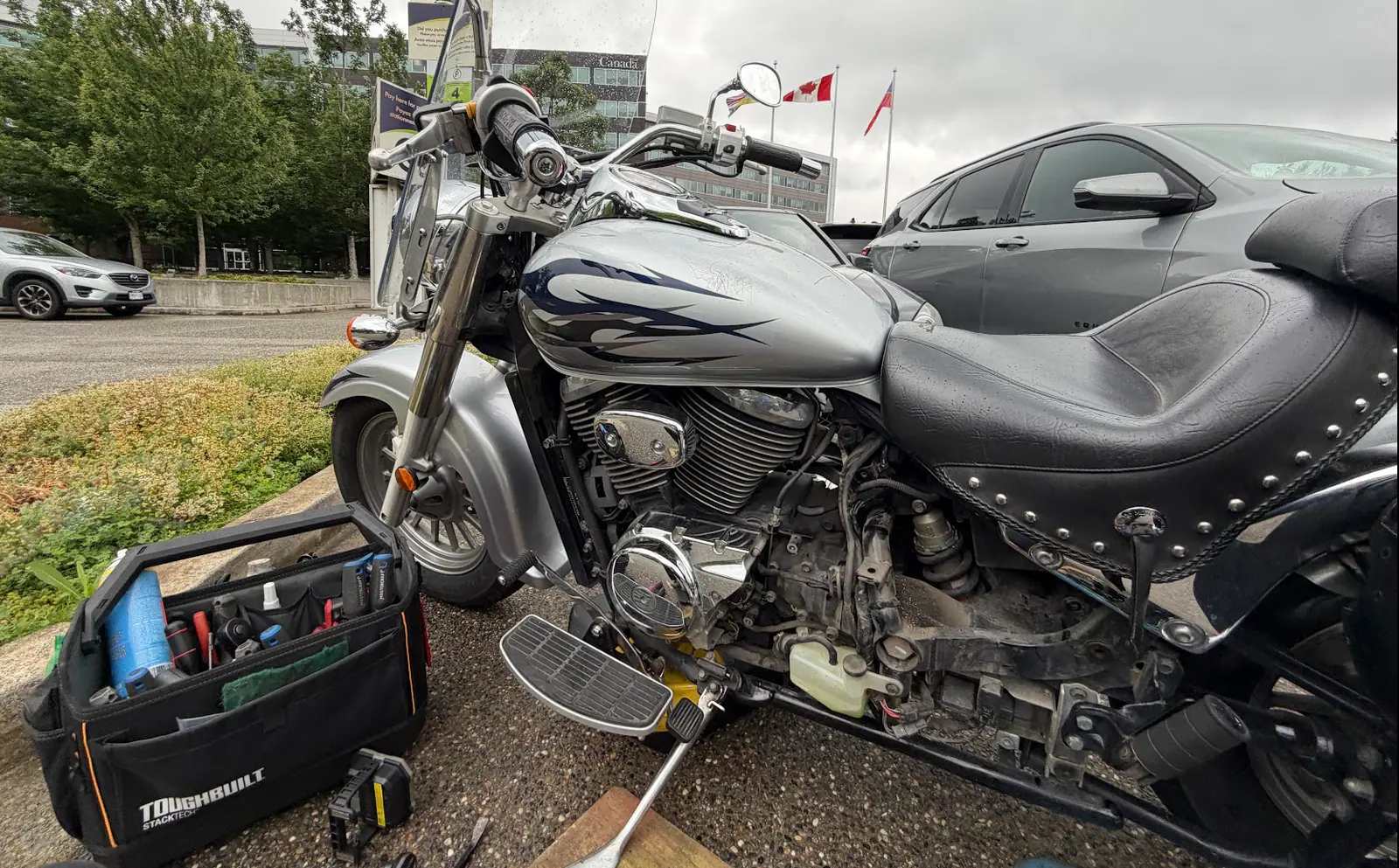 Motorcycle engine and foot-control area being checked during mobile service